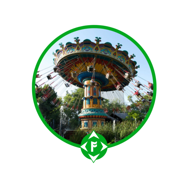 Atracción de sillas voladoras girando en Isla Mágica, parque temático de Sevilla, rodeada de árboles y vegetación, enmarcada con el logotipo verde de Ansur-TEILFE en la parte inferior